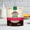 The Burning Desire Cornmeal from Doudlah Farms Organics, made in Wisconsin, takes center stage on the kitchen counter. A tempting slice of cake and a glass of milk behind it promise a deliciously fiery touch to your cooking adventures.