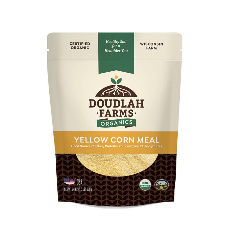 A 24 oz bag of Doudlah Farms Yellow Organic Corn Meal. The packaging proudly highlights its Certified Organic status, sourced from a Wisconsin farm with Healthy Soil for a Healthier You. It's labeled as a good source of fiber, proteins, and complex carbohydrates.