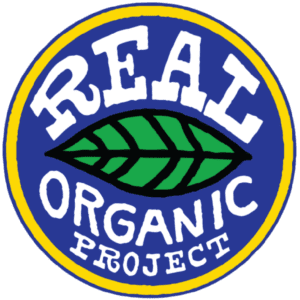 The logo of the Real Organic Project spotlights a green leaf at its center against a blue backdrop, with the words REAL ORGANIC PROJECT in bold white letters encircled by a yellow border, symbolizing its commitment to going beyond organic standards.