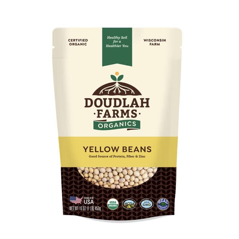 A package of Doudlah Farms Organics Yellow Canary Beans, showcasing labels for certified organic, non-GMO, and made in the USA. This 1LB pack is a great source of protein, fiber, and zinc.