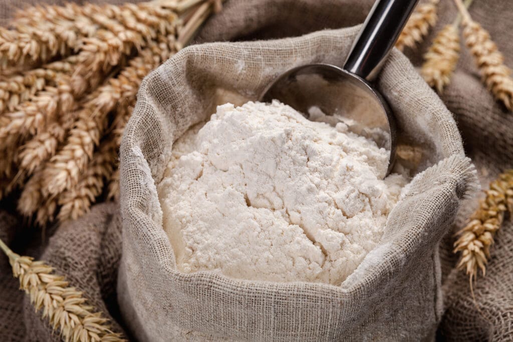 A rustic sack of organic flour with wheat stalks, representing natural and unprocessed baking ingredients for clean eating.