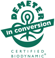 Green Demeter Certified Biodynamic In Conversion logo, featuring a stylized plant and circular design, indicating a product or farm is transitioning to biodynamic certification.