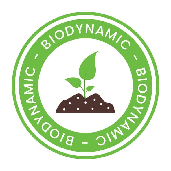 A green circular badge with the word BIODYNAMIC repeated along the border, featuring a sprouting plant with two leaves emerging from soil in the center.