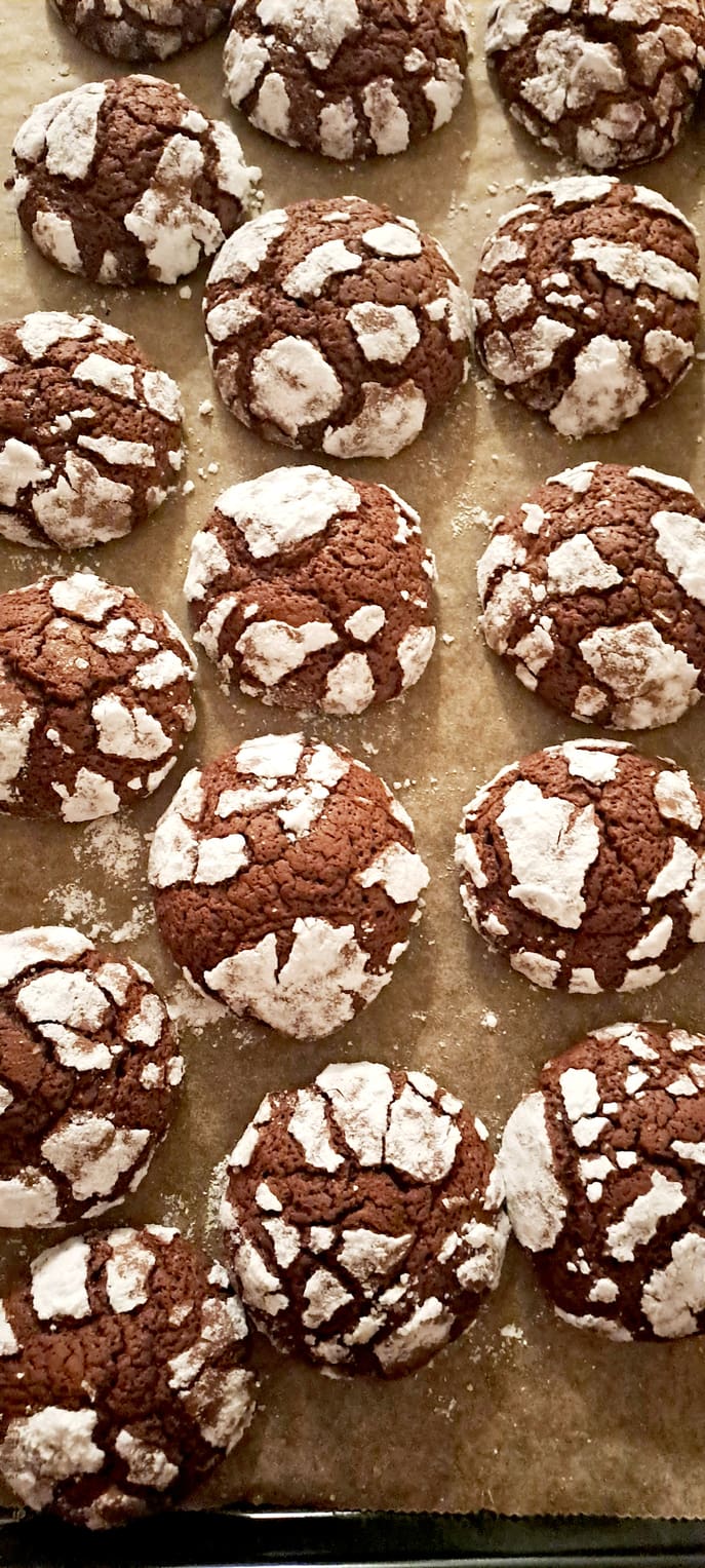 Home made chocolate buckwheat crinkle cookies, fresh baked on baking pan, close up, from above