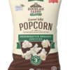 A bag of Popped Popcorn from Doudlah Farms Organics, made with coconut oil and Utah sea salt, bearing the Regenerative Organic Certified label and displaying popcorn images along with multiple certification badges on the front.